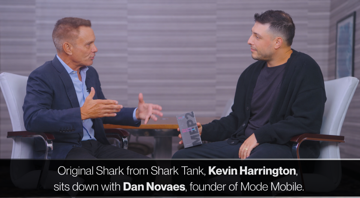 Kevin Harrington, original Shark Tank investor, sits across from Mode Mobile CEO Dan Novaes during a televised interview.